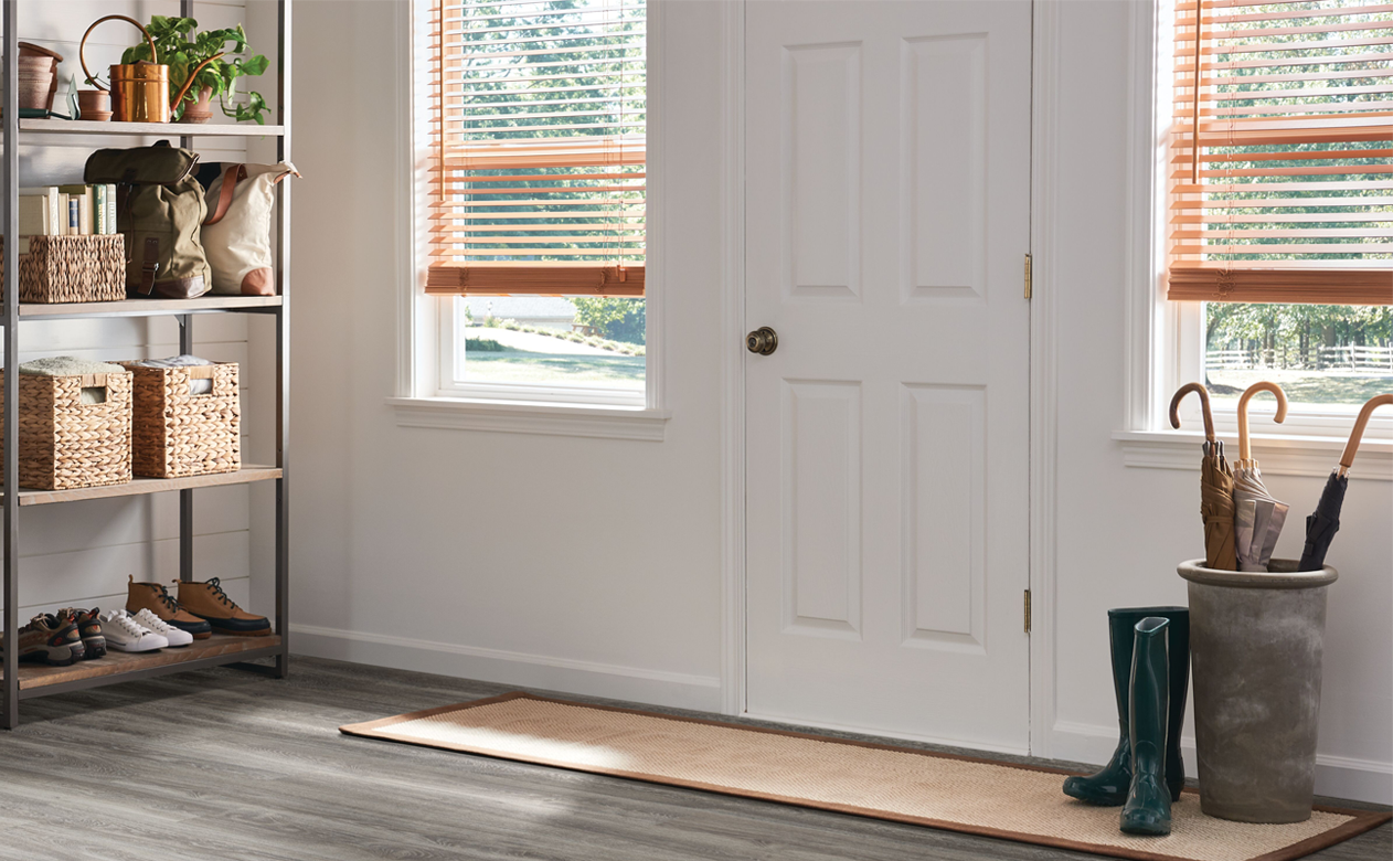 entryway with wooden blinds, rainboots and an umbrella holder